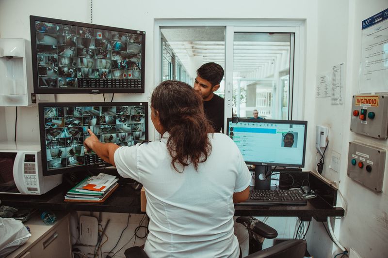 Central de monitoramento do Grupo Distrital com operadores acompanhando câmeras