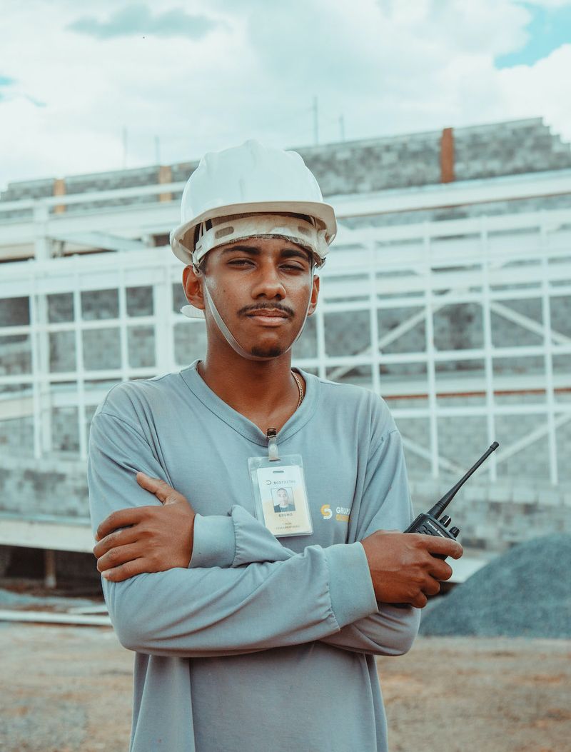 Profissional do Grupo Distrital com capacete e rádio acompanhando a operação de uma estrutura predial